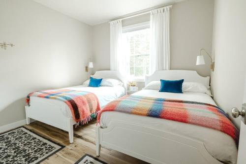 due letti in una stanza bianca con una finestra di Prinsen Retreat a Ellison Bay