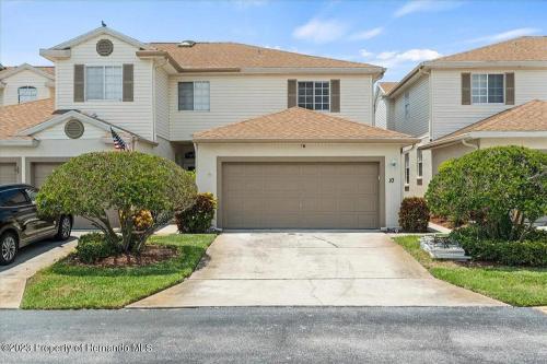 a house with a garage in front of it at Sunset Palm Stay - Cozy Retreat Near Gulf Beaches in St. Petersburg