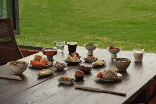 een houten tafel met verschillende soorten voedsel erop bij Hongyuan Weilu Nomadic Luxury Camp in Hongyuan