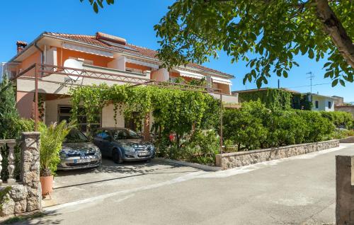 two cars parked in front of a house at Apartments and Rooms Dobrila in Jelsa