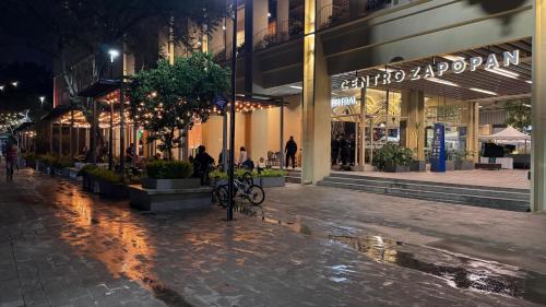 an empty street in front of a store at night at Centro Zapopan in Cedro