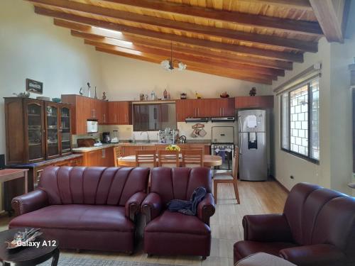un soggiorno con divano e cucina di Rose Garden a Guayllabamba