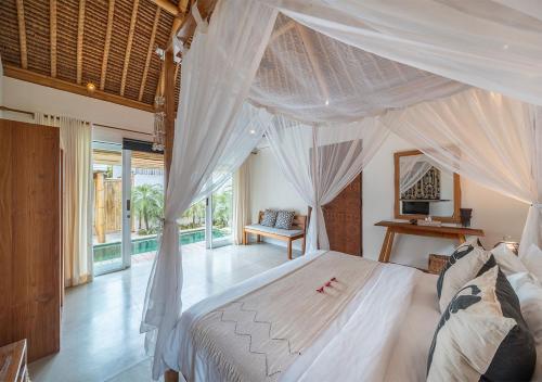 レンボンガン島にあるVilla Lagartoのベッドルーム(大きな白いベッド、カーテン付)