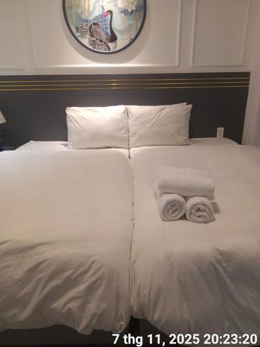 ein weißes Bett mit zwei Handtüchern darauf in der Unterkunft Inn Saigon Hotel in Ho-Chi-Minh-Stadt