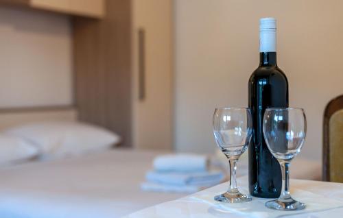 a bottle of wine sitting on a table with two wine glasses at Apartments and Rooms Dobrila in Jelsa