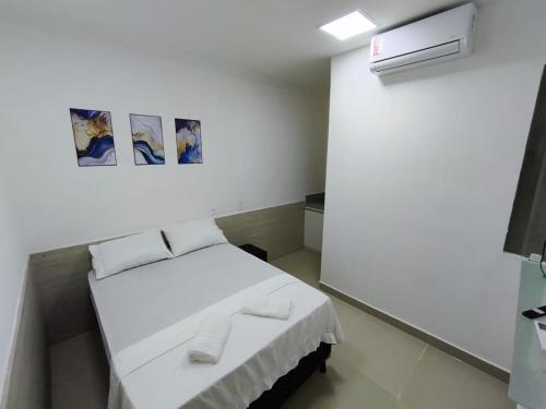 a small white room with a bed in it at Essenza Suites Natal in Natal