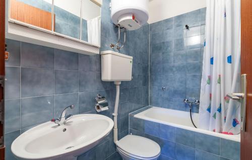 a bathroom with a sink and a toilet and a tub at Apartments and Rooms Dobrila in Jelsa