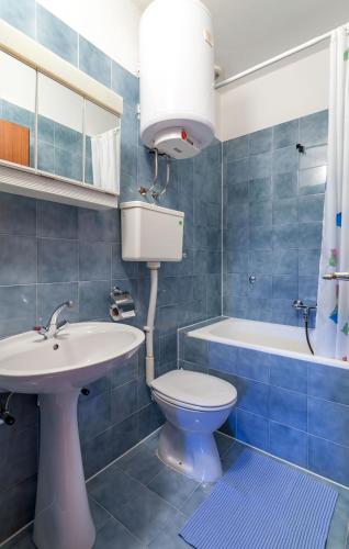a bathroom with a sink and a toilet and a tub at Apartments and Rooms Dobrila in Jelsa