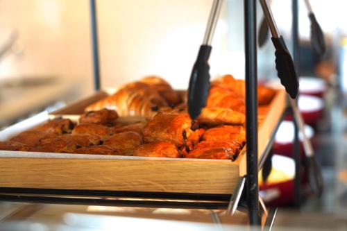 アルクマールにあるHotel Alkmaar - Bar & Restaurantのテーブルの上に置かれたパンとペストリーのトレイ