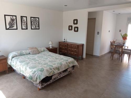 ein Schlafzimmer mit einem Bett und einem Tisch und Stühlen in der Unterkunft ELINOR-CASA PLAYERA in Santa Clara del Mar