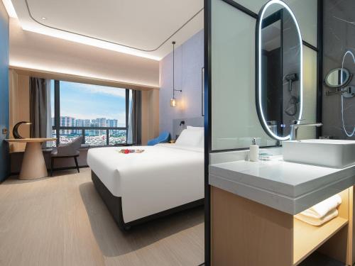 een hotelkamer met een bed, een wastafel en een spiegel bij Country Inn & Suites by Radisson - Taishan East Branch in Taishan