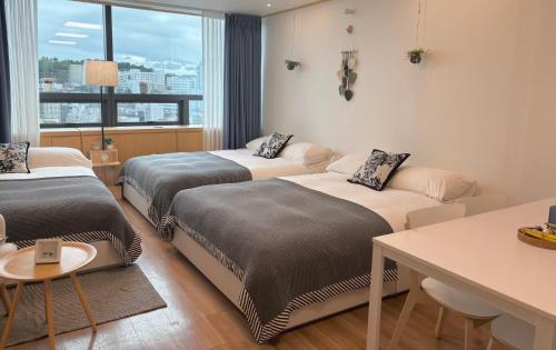 a hotel room with two beds and a table at Hongdae sub 1min in Seoul