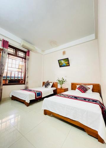 a bedroom with two beds and a window at Mai Chau Bình Minh Hotel in Mai Châu