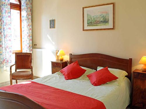 Un dormitorio con una cama con dos almohadas rojas. en Gîte lumineux avec jardin, draps inclus, près de Vichy - FR-1-489-281, en Trézelles