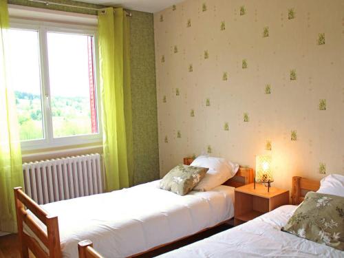 ein Schlafzimmer mit zwei Betten und einem Fenster in der Unterkunft Gîte Chez Mamie - Charme Vintage près de Lavoine - FR-1-489-332 in Lavoine