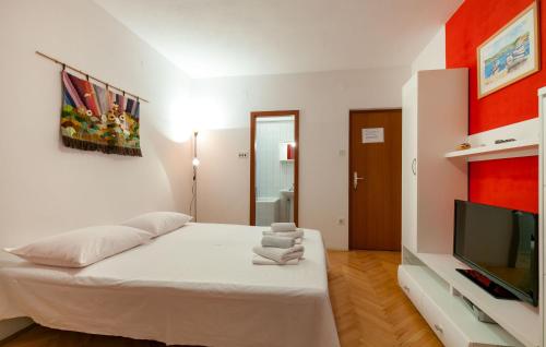 a white room with a bed and a flat screen tv at Apartments and Rooms Dobrila in Jelsa
