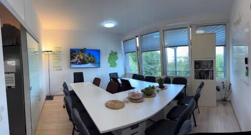 a conference room with a white table and chairs at AECOspires CoWorkStel in Munich
