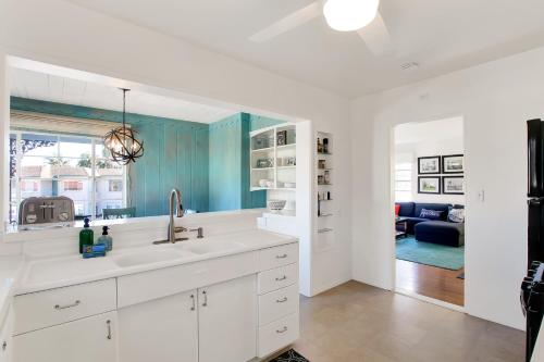 een witte keuken met spoelbak en een woonkamer bij West Beach Villas 1 & 2 in Santa Barbara