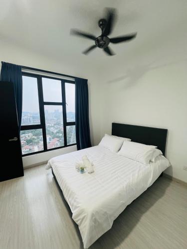 a bedroom with a white bed with a ceiling fan at Spacious 3B3R Unit in BukitJalil in Kuala Lumpur