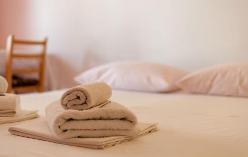 a pile of towels sitting on top of a bed at Apartments and Rooms Dobrila in Jelsa