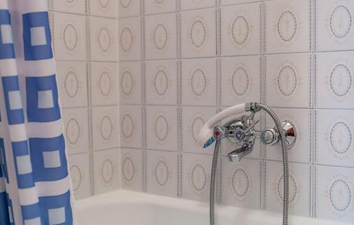 a shower head in a bathroom with a tub at Apartments and Rooms Dobrila in Jelsa