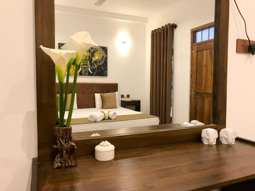 een slaapkamer met een bed en een grote spiegel bij The Mammoth udawalawe in Udawalawe