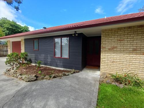 a black house with a red roof at House in Restful Setting in Whangarei