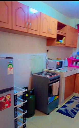 a kitchen with a stove and a refrigerator at Bustani Homes apartment in Kahawa