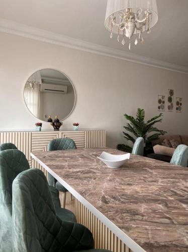 une salle à manger avec une grande table en marbre et des chaises dans l'établissement شقة فاخرة, à Madinaty