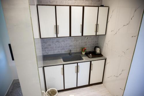 a kitchen with white cabinets and a sink at aroya in Jeddah