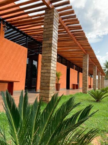 a building with a wooden roof and some plants at Pousada Jalapão Sunset in Mateiros