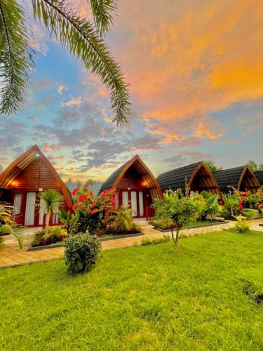 a row of cottages in a resort with a lawn at Golden Beach Hotel Lombok in Pulau Gilipoh