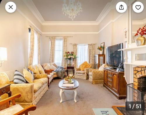 a living room with a couch and a table at Blackwood House in Healesville