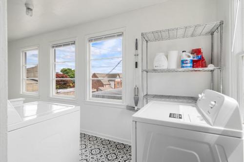 a white bathroom with a sink and a window at King Bed, Near DT and Best Restaurants, Pets OK! in Tacoma
