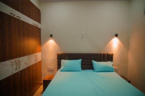 Un dormitorio con una cama grande con almohadas azules. en Girivan, en Alwar