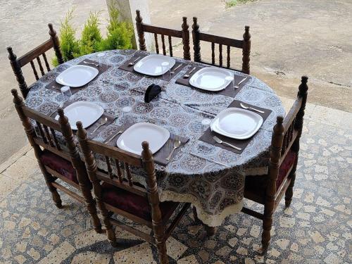 a wooden table with plates and dishes on it at Mountain Pearl Villa in Avathi