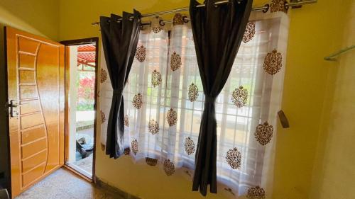a window with black curtains in a room at Mountain Pearl Villa in Avathi