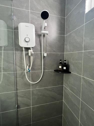 een douche met een douchekop in een badkamer bij Kudat Golf View Villa in Kudat