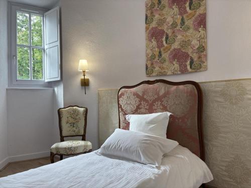 a bedroom with a bed and a window and a chair at Gîte paisible dans château avec jardin en Auvergne - FR-1-489-604 in Louchy-Montfand
