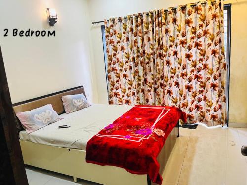 a bedroom with a bed with a red blanket on it at Candy Stay's 2BHK with Pvt Pool in Lonavala