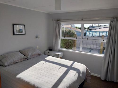 a bedroom with a bed and a large window at Sweet on Sutton in Richmond