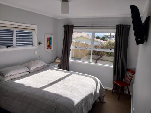 a bedroom with a bed and a large window at Sweet on Sutton in Richmond