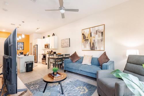 ein Wohnzimmer mit einer blauen Couch und einem Fernseher in der Unterkunft Riverwalk Luxury Haven Pool Free Parking in San Antonio