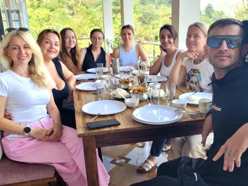 a group of people sitting around a table at Riva palace Homestay Rewalsar Lake in Malther