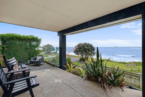 a patio with a view of the ocean at Wow On Wanaka Bay - beachfront living at its best in New Plymouth