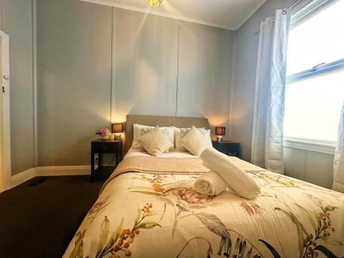 ein Schlafzimmer mit einem großen Bett mit einem großen Fenster in der Unterkunft Magnolia Cottage in Healesville