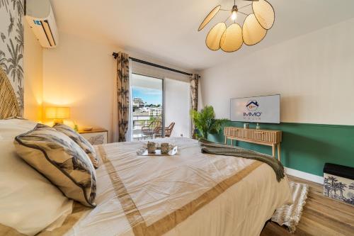 a bedroom with a large bed and a window at L Escapade - Studio tropical chic et parking prive in Saint-Denis
