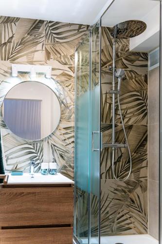 a bathroom with a shower and a mirror at L Escapade - Studio tropical chic et parking prive in Saint-Denis