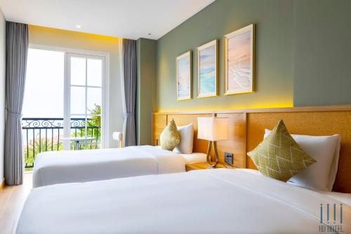 フーコックにあるHD Hotel Sunset Townのベッド2台とバルコニー付きのホテルの部屋