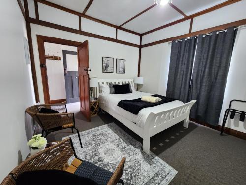 Un dormitorio con una cama, una silla y un sofá. en Bowen Toft Villa- New Listing, en Sandy Bay